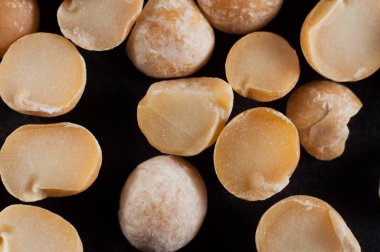 Koyu bir arka plan üzerinde dilimler ile kuru bezelye, yakın çekim. Makro sho