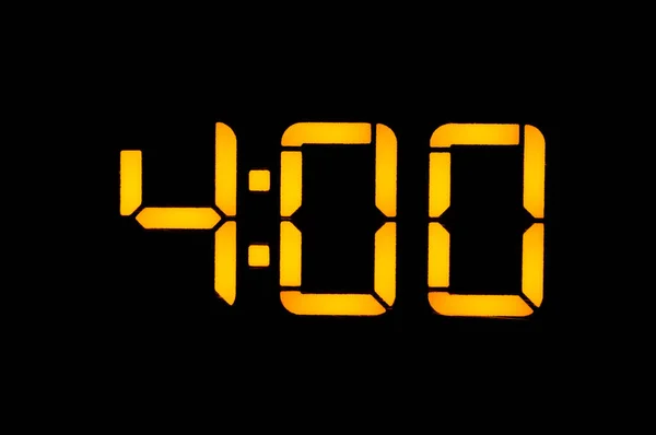 Relógio digital eletrônico com números amarelos em um backgrou preto — Fotografia de Stock