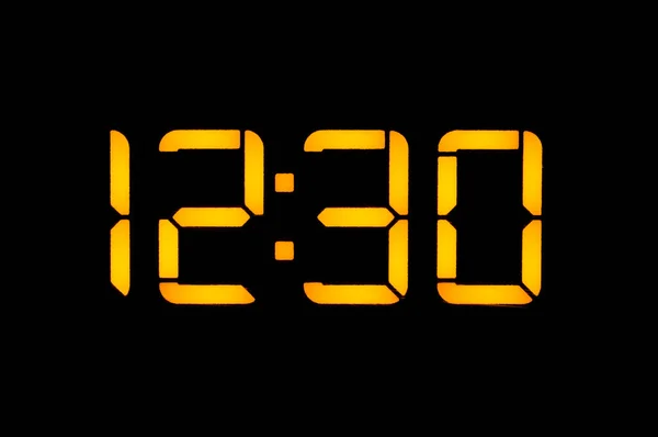 Електронний цифровий годинник з жовтими номерами на чорному фоні — стокове фото