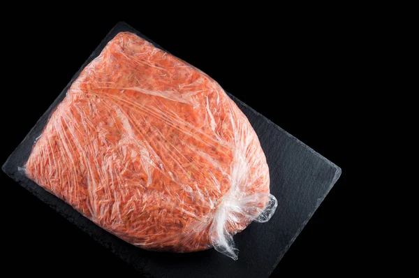 Cenouras trituradas caseiras congeladas em um saco plástico em uma pla de pedra — Fotografia de Stock