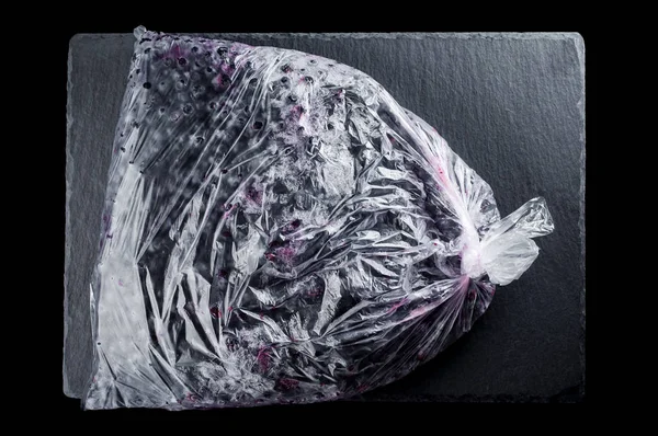 Bevroren huisgemaakte krenten in een plastic zak op een steen plaat op een — Stockfoto
