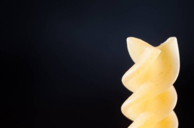 Koyu mavi arka plan üzerinde durum buğday spiral makarna, yakın-u