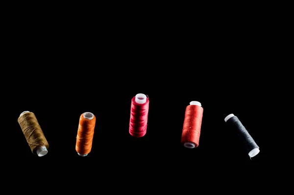 Black, bronze, orange, red and pink threads floating in the air — Stock Photo, Image