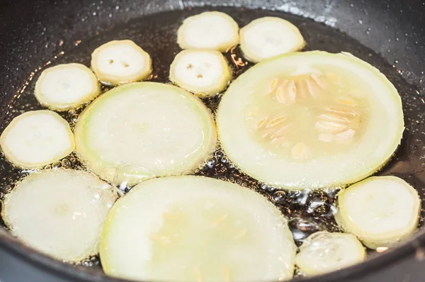 Fruit thuis gesneden courgette in een pan in zonnebloemolie. — Stockfoto