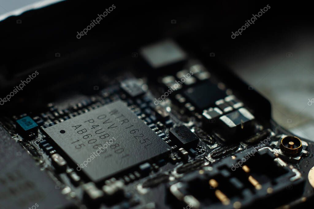 Kiev, Ukraine - May 6, 2020: Transceiver on the iphone se motherboard closeup.