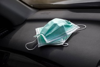 Arabanın ön konsoluna yerleştirilen tıbbi yüz maskesi, Coronavirus (COVID-19) önleme konsepti