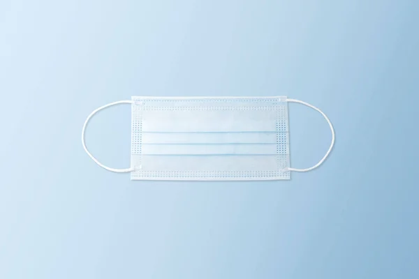 Disposable face mask on the blue color background, Coronavirus (COVID-19) and influenza infection prevention concept
