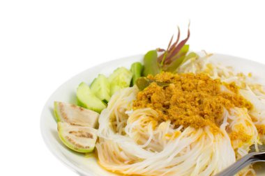 Körili balık soslu pirinç eriştesi ve beyaz arka planda beyaz tabakta sebze.