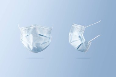Mavi arka planda tek kullanımlık yüz maskesi, Coronavirus (COVID-19) ve grip enfeksiyonu önleme konsepti