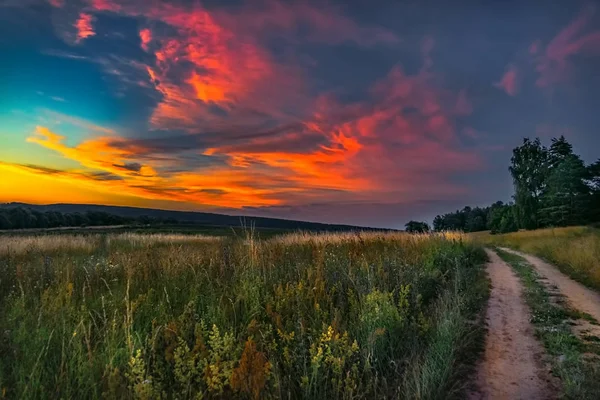 Sonnenuntergang über einem ländlichen Fußweg im Tal Stockfoto