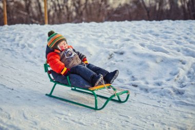Bir atlı kızak yolculuğu zevk çocuk. Çocuk bir kızak sürme. Çocuk oyun açık havada karda. Çocuklar kızak kış Park.