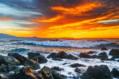 Fırtına denizin dalgaları ile altında parlak günbatımı sıçramalarına