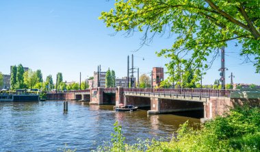 Amsterdam, 7 Mayıs 2018 - küçük bir tekne ile Berlage Köprüsü yakınındaki Merkezi Amsterdam Amstel Nehri üzerinde yaz döneminde geçen yelkenlileri