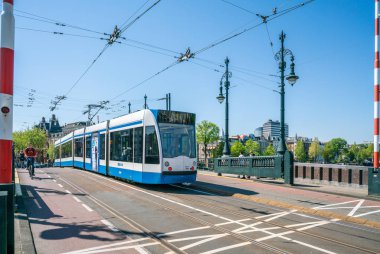 Amsterdam, 7 Mayıs 2018-yaz aylarında yakınındaki Merkezi Amsterdam Amstel Nehri üzerinde yeni Amstelbrug geçen tramvay