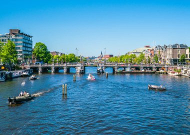 7 Mayıs 2018 - Amsterdam, görüntülemek Amstel küçük tekneler ve Sarphatistraat Köprüsü ile dolu bir yaz gününde Nehri üzerinde