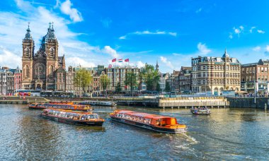 Amsterdam, Hollanda, 18 Ağustos 2019: Nicolaas Kilisesi 'nin ormanlık alanında turist taşıyan kanal tekneleri