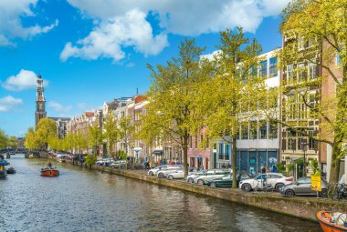 Amsterdam, Hollanda, 22 Nisan 2017: Turistler Prinsengracht 'ta bir kanala yelken açarak Westertoren' i geçiyorlar.