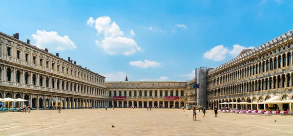 Venedik, İtalya - 29 Haziran 2020 - Çok az turist yazın güneşli bir Corona gününde Venedik şehir merkezindeki San Marco meydanından geçiyor