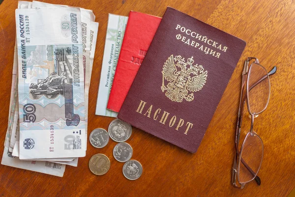 money, points and pension certificate on a wooden surface-translation into Russian: pensioner\'s certificate.