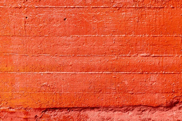 Old plastered wall painted with fresh red paint. Abstract background of red walls. close up