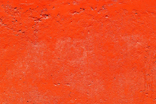 Old plastered wall painted with fresh red paint. Abstract background of red walls. close up