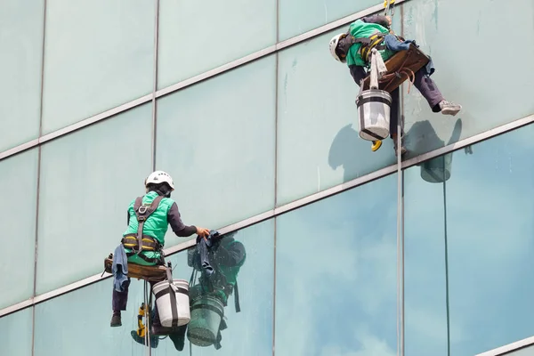 Grupp arbetstagare rengöring fönster service på höghus byggnad — Stockfoto