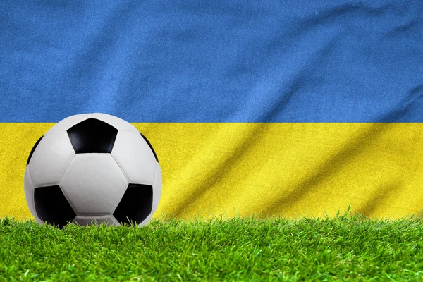 Fotboll på gräs fält med våg flagga av Ukraina — Stockfoto