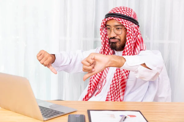 Arabian businessman feeling disappoint while talking with his business partner by video conference on notebook in his office