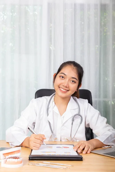 Een Vrouwelijke Dokter Glimlacht Terwijl Met Haar Computer Notebook Werkt — Stockfoto