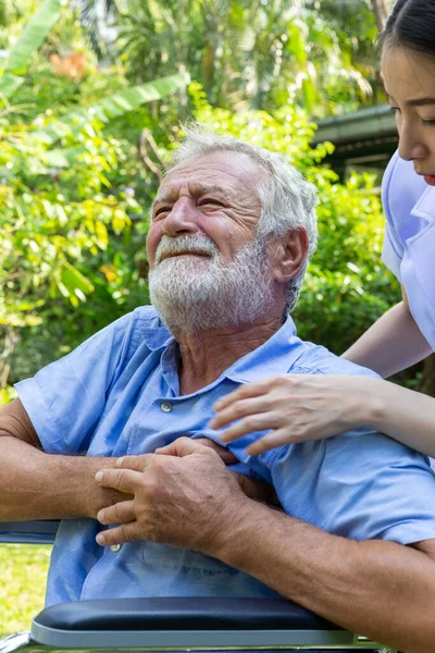 senior retirement man is heart attack while under healthcare by nurse in a garden