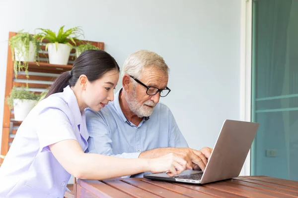 Infirmière Aider Homme Retraité Senior Travaillant Avec Ordinateur Portable Maison — Photo