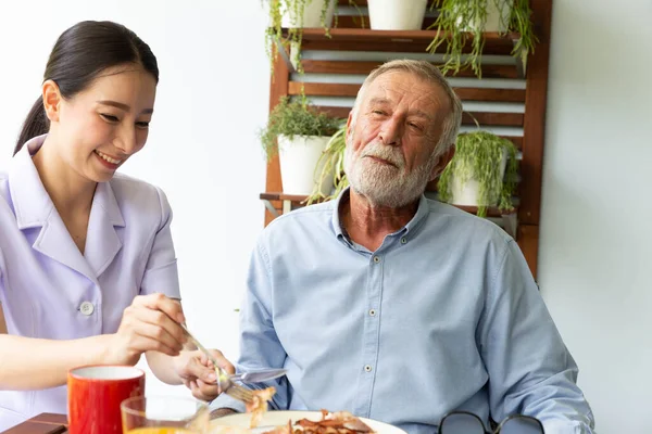 Asiatisch Krankenschwester Hilfe Glücklich Senior Pensionär Mann Having Breakfast Zusammen — Stockfoto