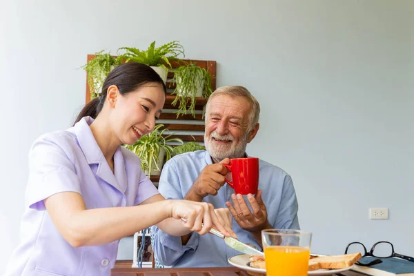 Asiática Enfermera Disfrutar Asistir Senior Hombre Teniendo Desayuno Feliz Juntos —  Fotos de Stock