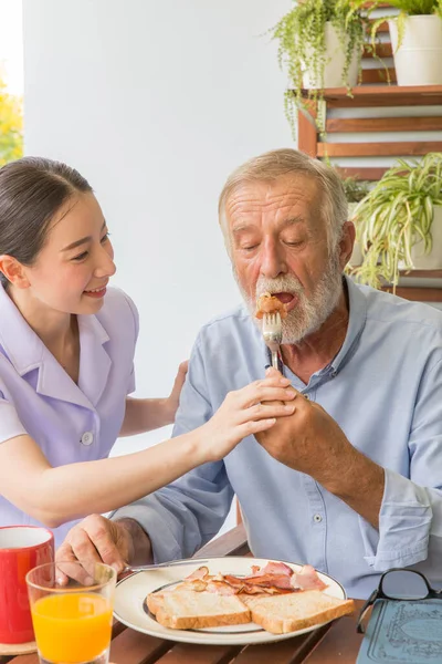 Krankenschwester Hilft Seniorin Beim Gemeinsamen Frühstück — Stockfoto