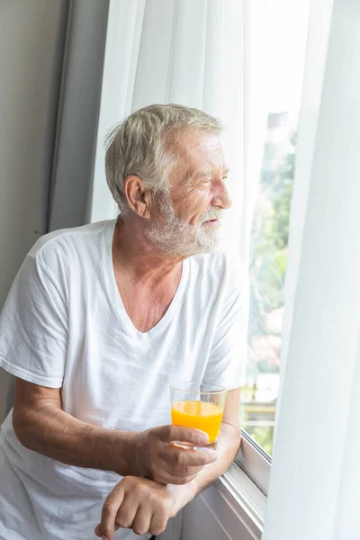 Rentner Steht Zimmerfenster Und Hält Ein Glas Orangensaft Der Hand — Stockfoto