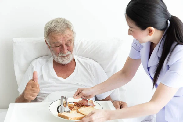 Enfermera Joven Cuida Hombre Jubilado Que Sirve Desayuno Cama Viejo —  Fotos de Stock