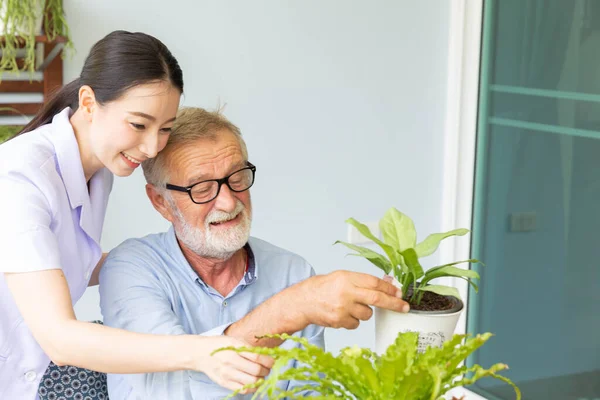 Jubilado Mayor Enfermera Están Regando Una Pequeña Planta Mientras Relajan —  Fotos de Stock