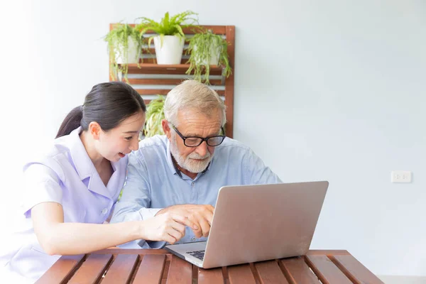 Infirmière Aider Homme Retraité Senior Travaillant Avec Ordinateur Portable Maison — Photo