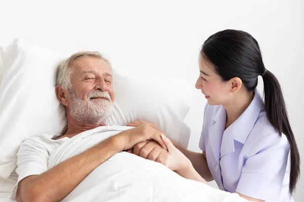 Krankenschwester Pflegt Älteren Mann Der Bett Liegt — Stockfoto