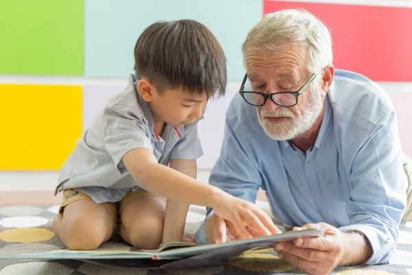 Dziadek Mały Uroczy Wnuk Czytają Razem Książkę Podłodze Ich Domu — Zdjęcie stockowe