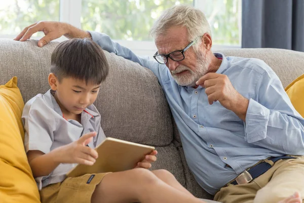 Abuelo Pequeño Nieto Lindo Jugando Tableta Táctil Juntos Sofá Casa —  Fotos de Stock