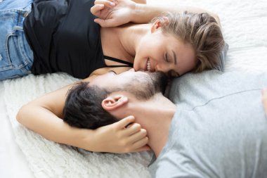 Birbirlerine aşık, mutlu bir çift, gülümseyen ve birbirlerini yatak odalarında öpen.