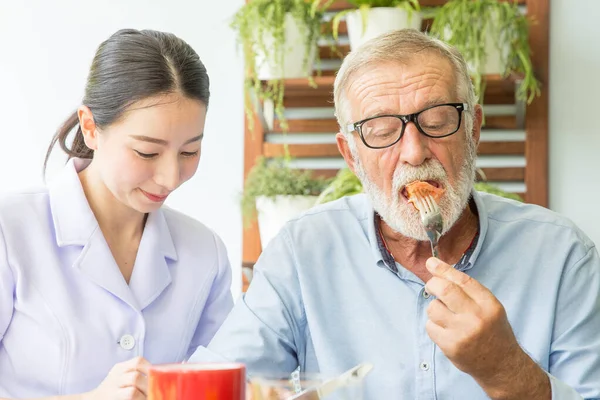 Enfermera Ayudar Hombre Mayor Desayunando Juntos —  Fotos de Stock