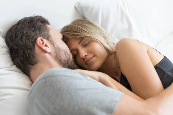 Young cute couple hug and sleep together in bed