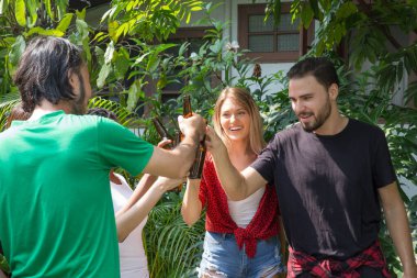 Bir grup arkadaş evin arka bahçesindeki barbekü partisinde eğleniyor ve mutlular.