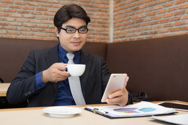 Hombre Negocios Asiático Usando Móvil Mientras Bebe Café Una Cafetería —  Fotos de Stock