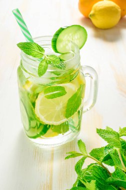 Dilimlenmiş limon, salatalık ve dal nane ahşap arka plan üzerinde infüzyon su Detoks.