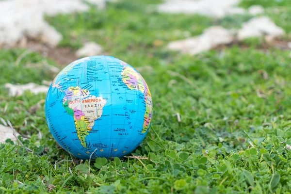 Small globe in the grass. Travel and global issues concept.