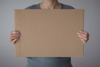 Bir kadın boş işareti ön yüzü beyaz arka planda tutar.