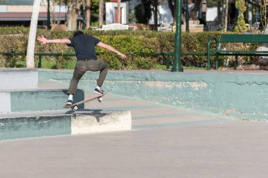 Skatepark bir kaykay hile yaparak kaykaycı.
